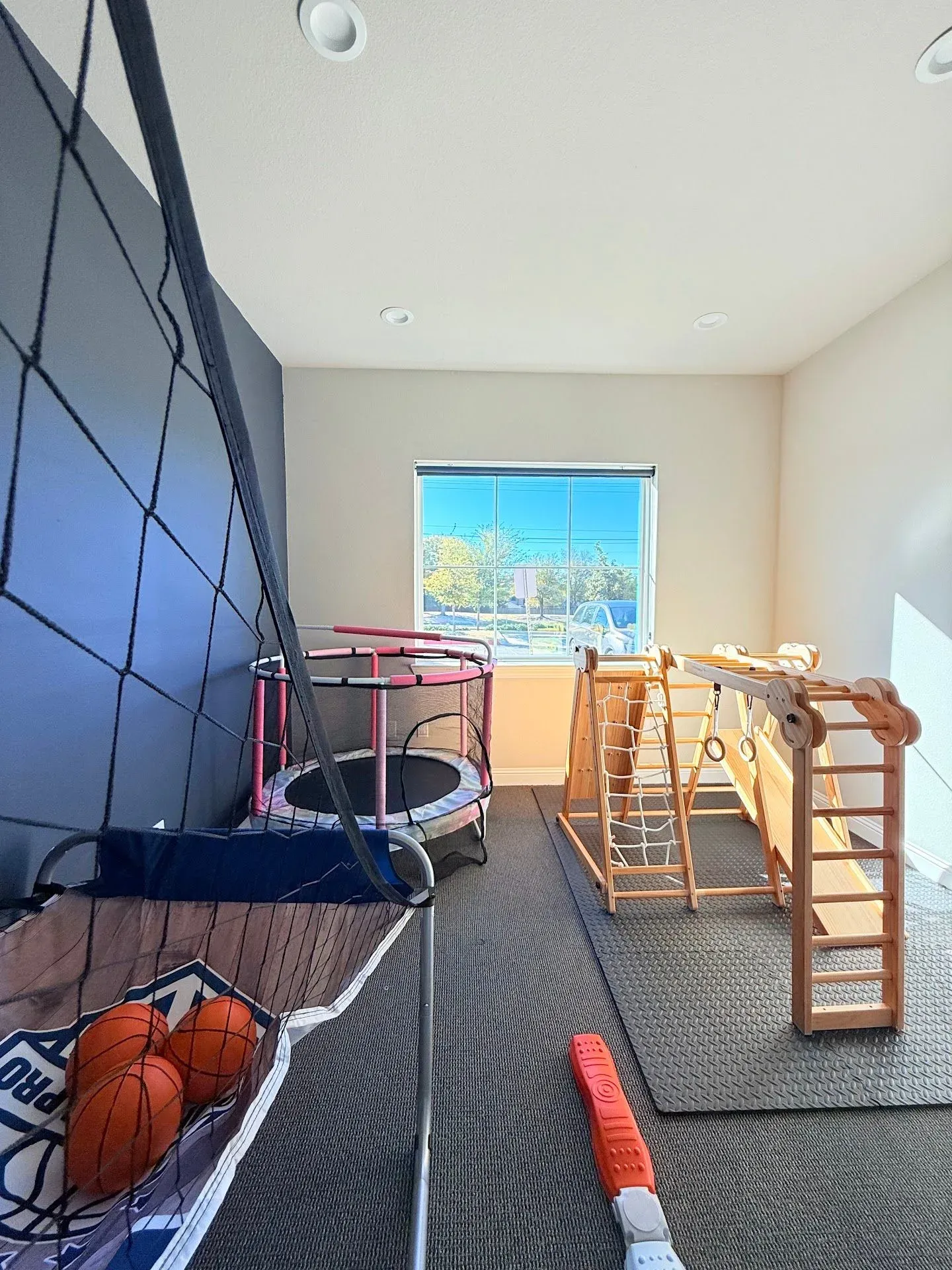 Sensory gym and active play room with trampoline and climbing frame for pediatric therapy