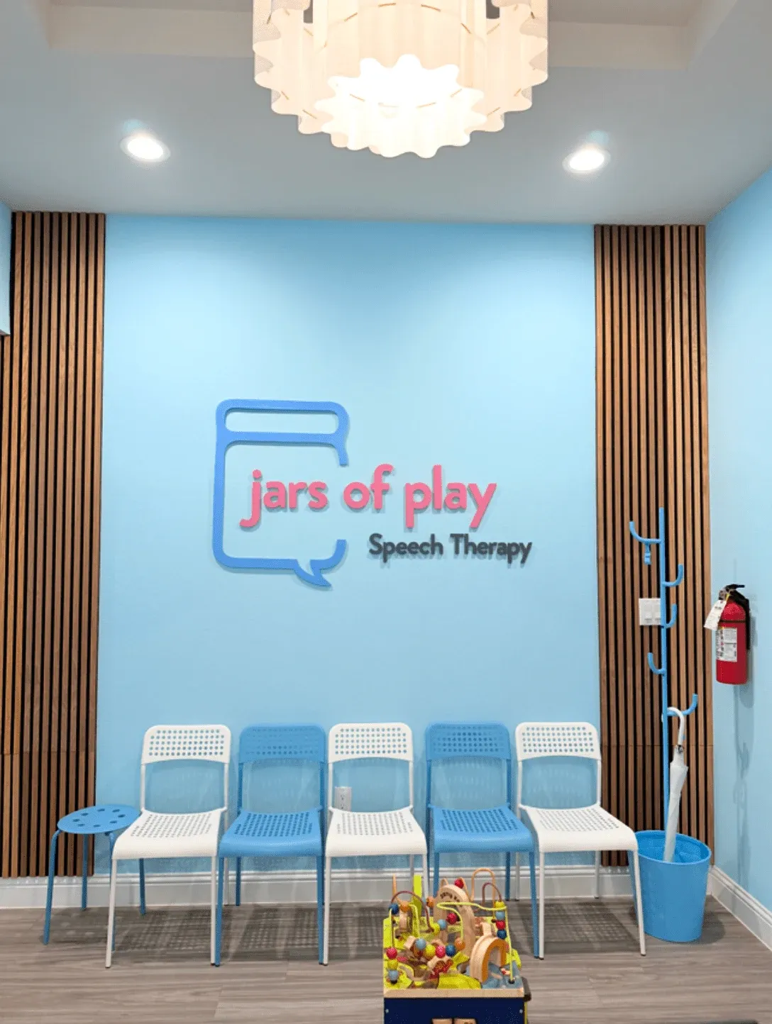 Jars of Play Speech Therapy waiting room in Prosper TX with branded logo wall sign